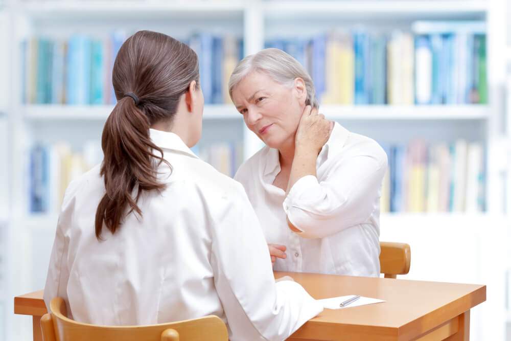 A woman seeing her doctor about fibromyalgia treatment