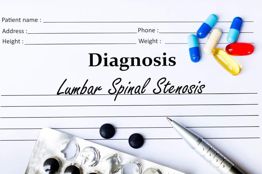 Lumbar spinal stenosis diagnosis written on a paper and lots of pills