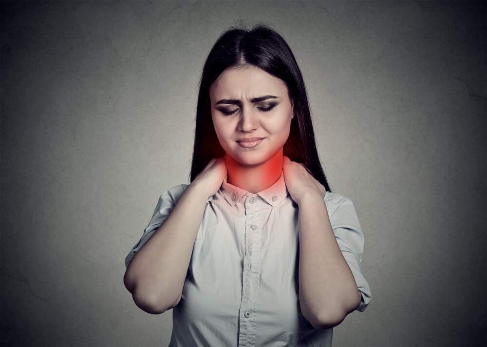 A young woman is suffering from neck pain